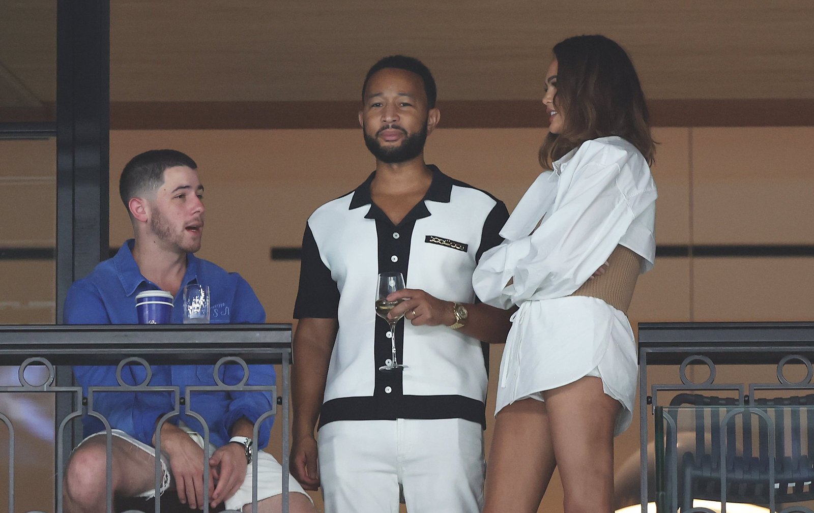 Nick Jonas (L) talks to John Legend and Chrissy Teigen