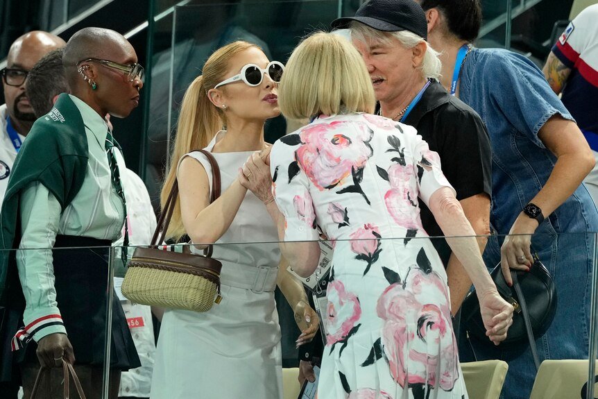 Ariana Grande greets Vogue Editor-in-Chief Anna Wintour and Australian director Baz Luhrmann at the Gymnastic graduation ceremony.